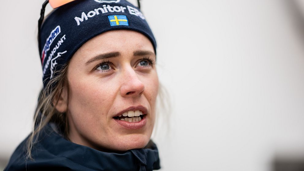 En person iförd en mössa med reklamlogotyper från sponsorer och ett par sportglasögon placerade ovanpå mössan.