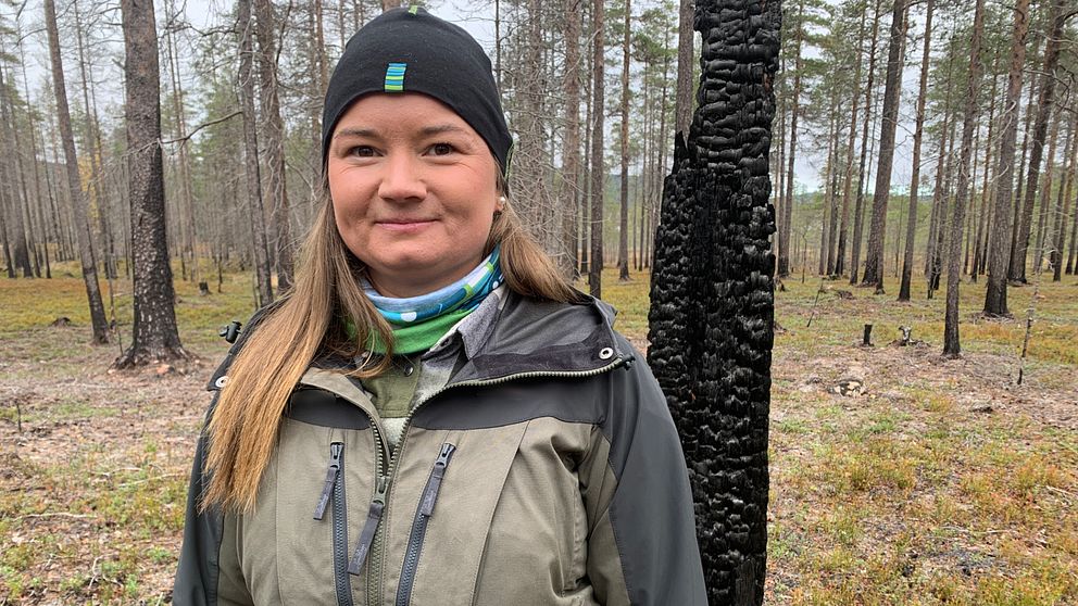 Therese Timber, natur- och miljövårdsspecialist på Sveaskog, står i ett naturreservat med brända tallar