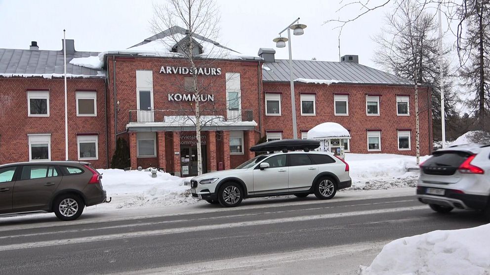 Exteriören på Arvidsjaurs kommunhus under vintertid där två bilar står parkerade.
