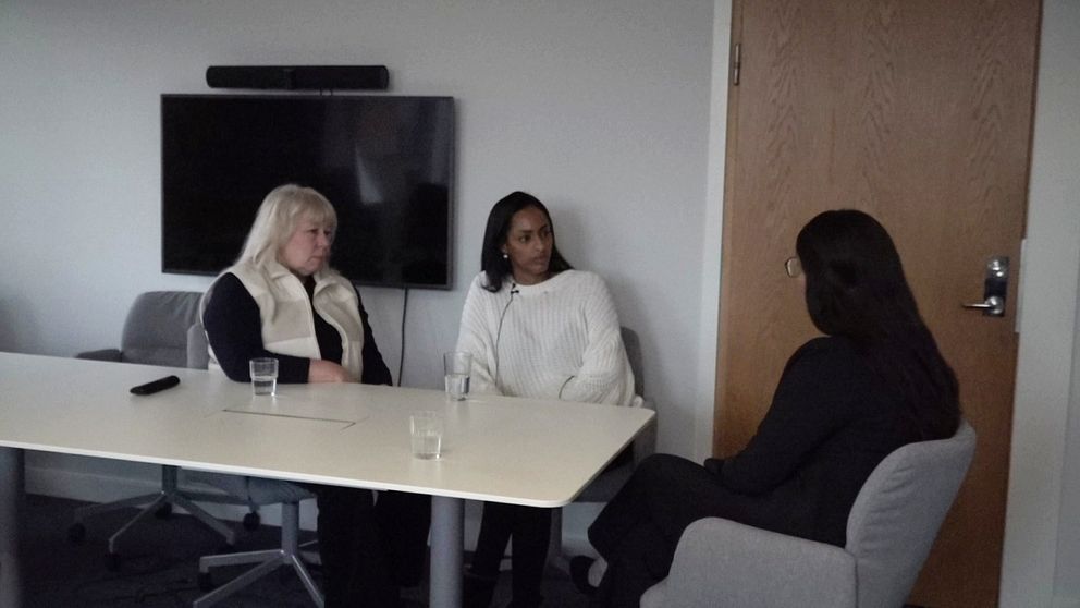 Tre kvinnor sitter vid ett bord i ett mötesrum.