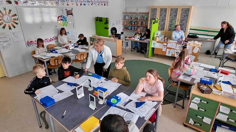 Elever och lärare arbetar engagerat i ett modernt klassrum.