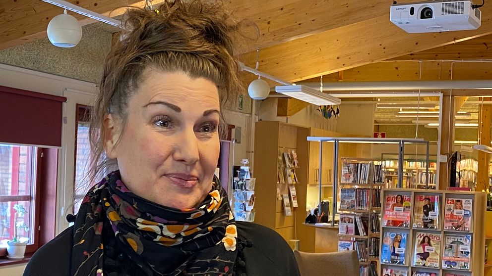 Kvinna i uppsatt hår i ett bibliotek
