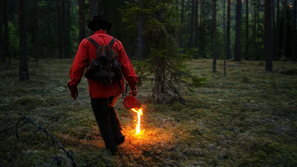 Man tänder eld på ris i skogen.
