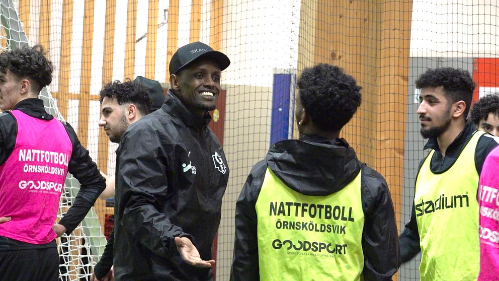 En grupp personer i träningsvästar deltar i nattfotboll inomhus i fotbollshallen i Örnsköldsvik.
