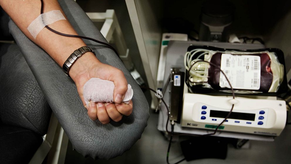 En person donerar blod, på bild syns en arm och blodpåse som fylls på.