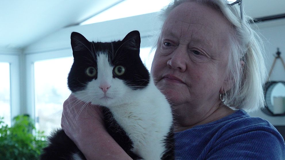 Äldre kvinna håller i en katt