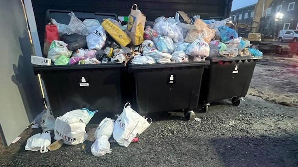 Överfulla sopkärl och skräp på marken vid Stegras bostäder i Boden.