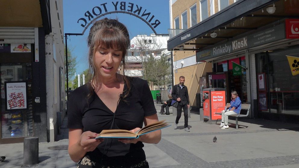 Kvinna läser bok i Rinkeby