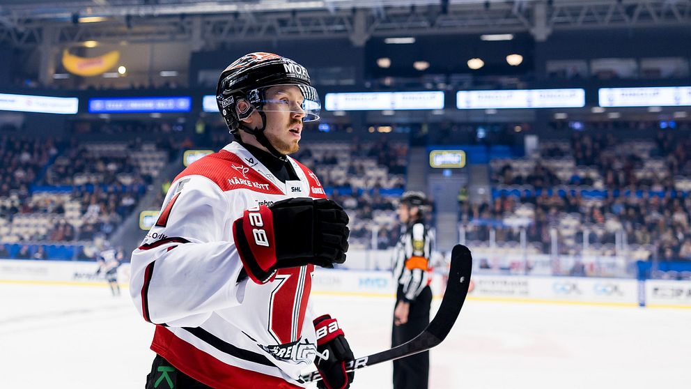 Ishockeyspelare går av isen under en match, publik syns i bakgrunden.