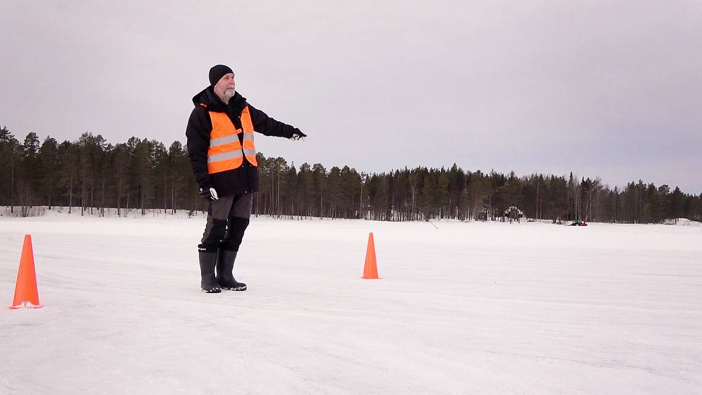 Trafiklärare står på isen vid halkbanan.