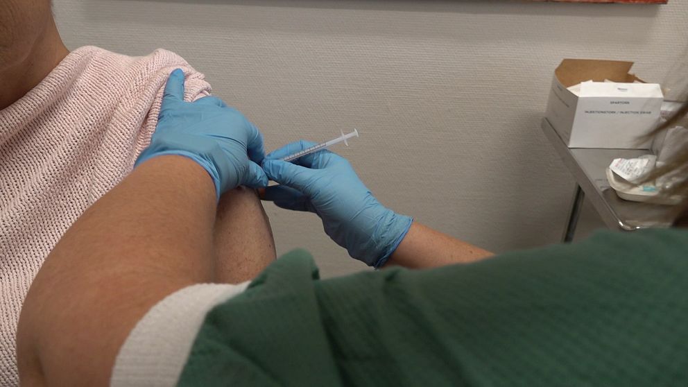 Spruta i armen när vårdpersonal ger en dos vaccin