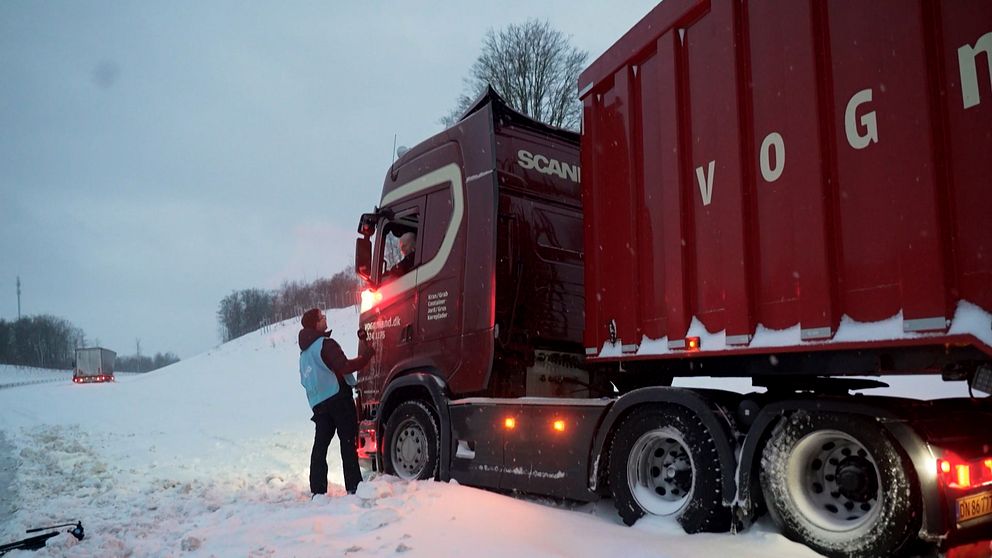 SVT:s reporter intervjuar en lastbilschaufför som sitter i sin röda lastbil.