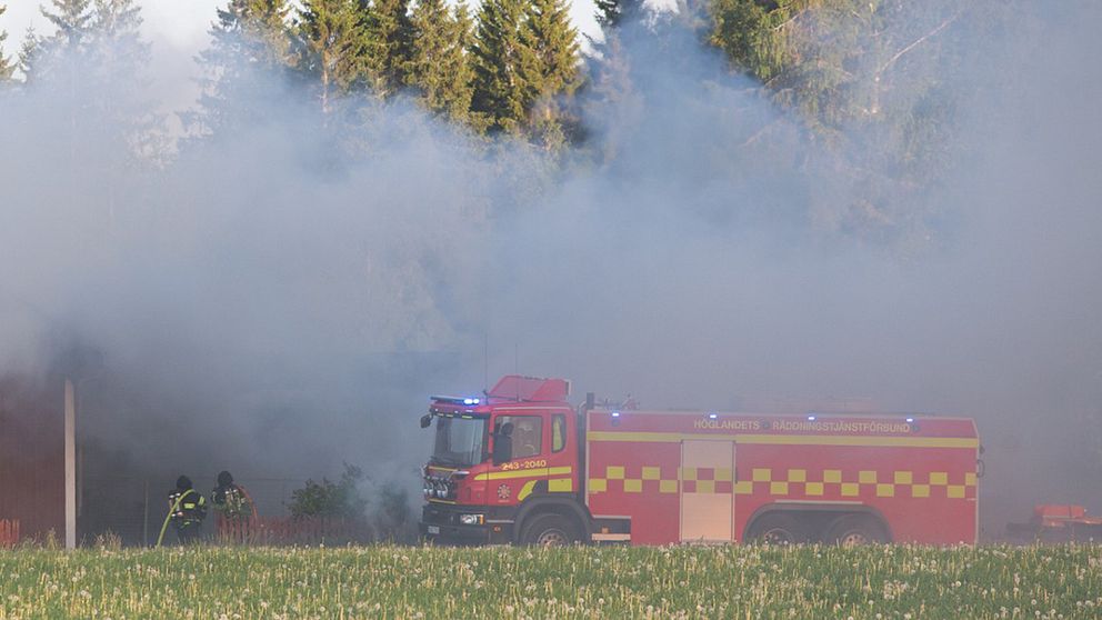 rök och brandbil framför husknut och skog