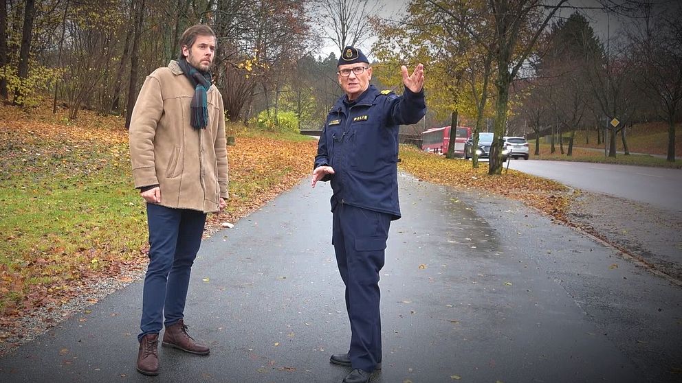 Reporter David Nilsson Hamne och polis står vid väg och polisen pekar mot kameran