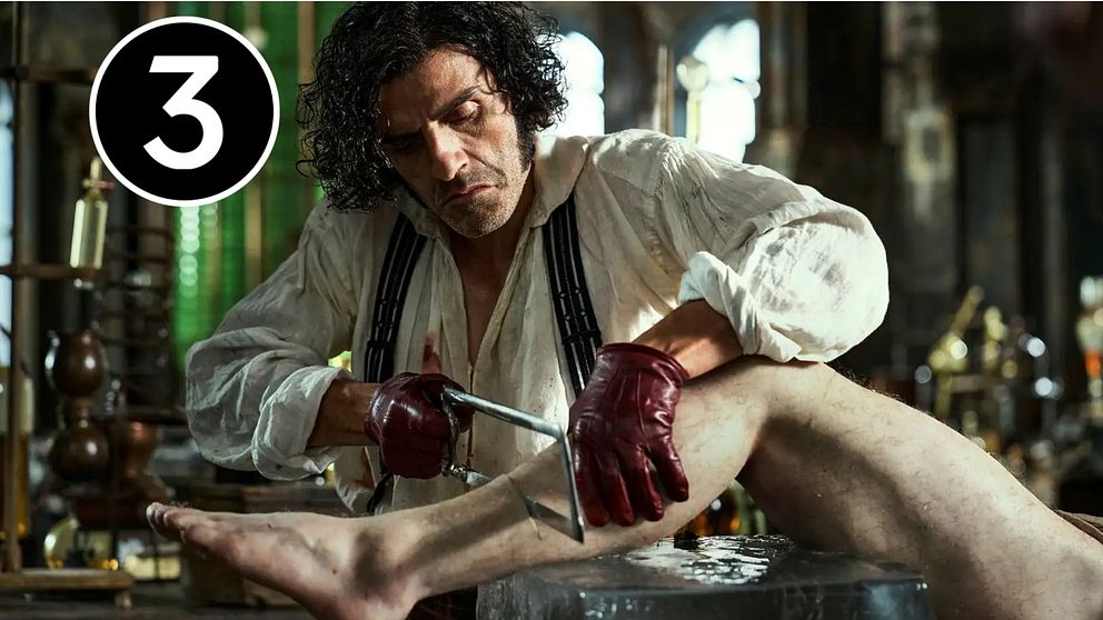 Oscar Isaac som Victor Frankenstein sågar i en död kropp i ett laboratorium i Guillermo Del Toros ”Frankenstein”