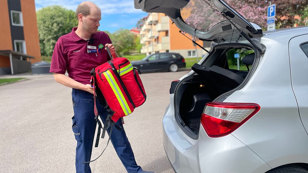 sjuksköterska lägger in vårdväska i bil