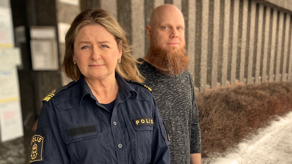 Kvinna i polisuniform står snett framför manlig utredare med rött skägg utanför polishuset i Falun