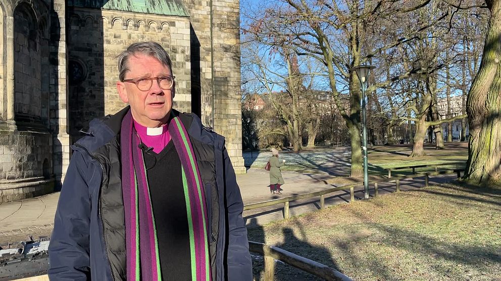 Biskop Johan Tyrberg med prästkrage står utomhus vid Lunds domkyrka en solig dag.