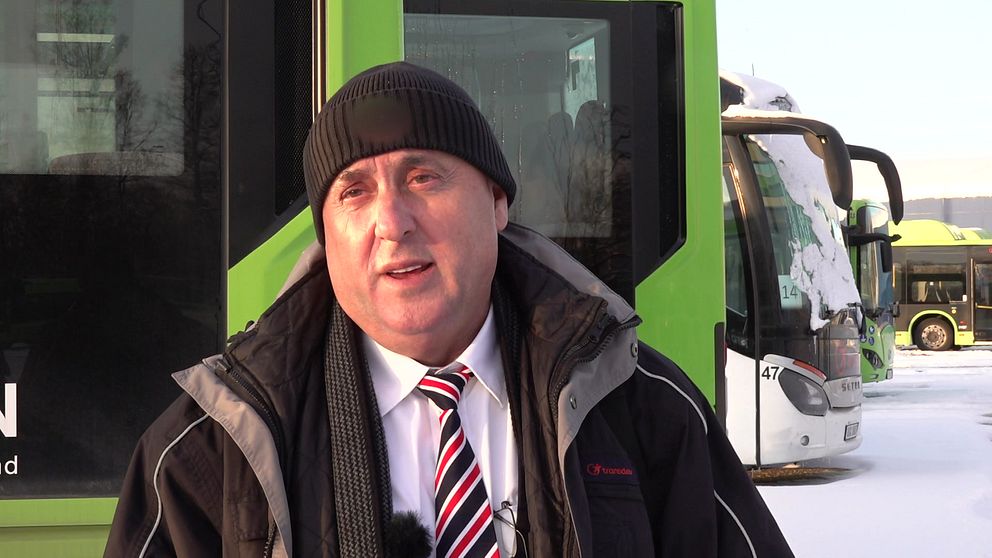 Busschauffören Hisni Rinasi står framför en buss i Eskilstuna.