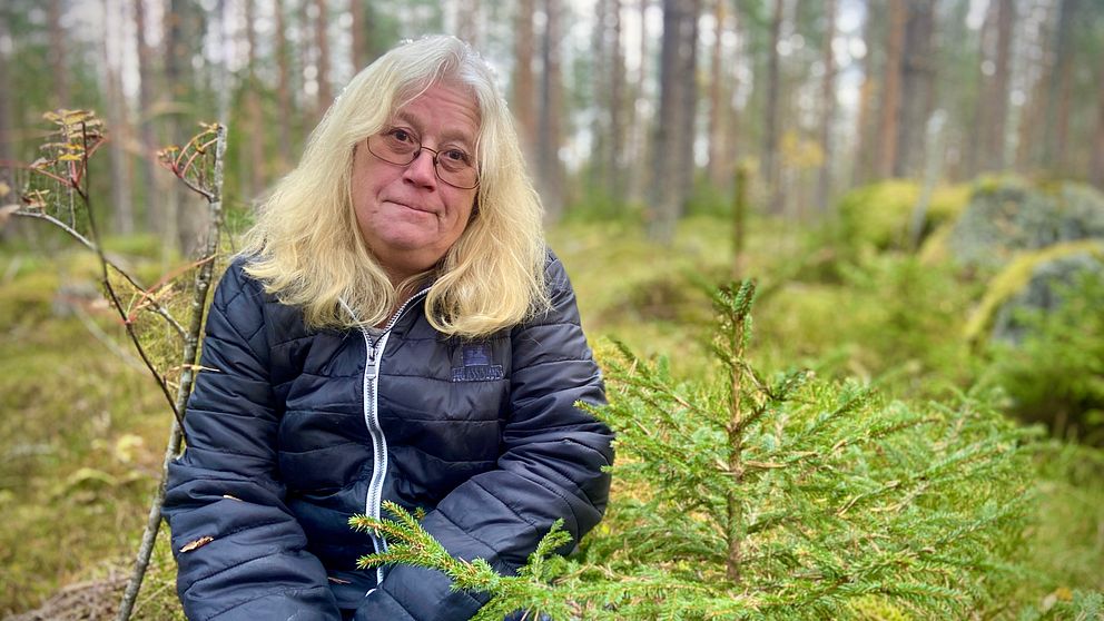 Carina Olhson (C), centerpolitiker i Nordanstig, sitter på huk i en skog.