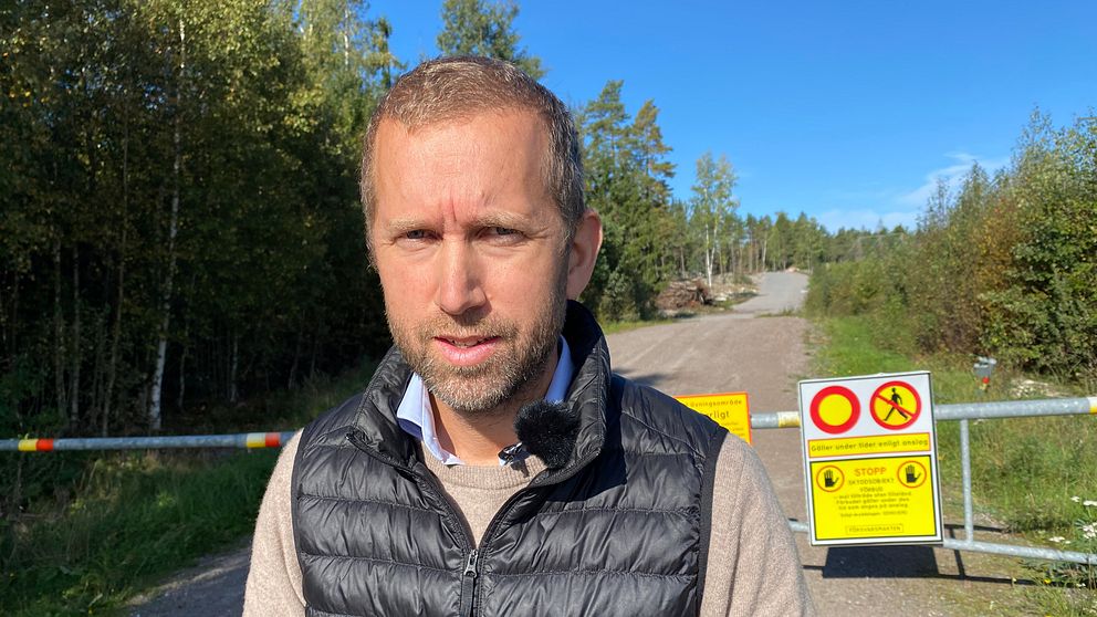Jacob Högfeldt (M) kommunalråd i Strängnäs, står framför grinden till skjutfältet i Härad.