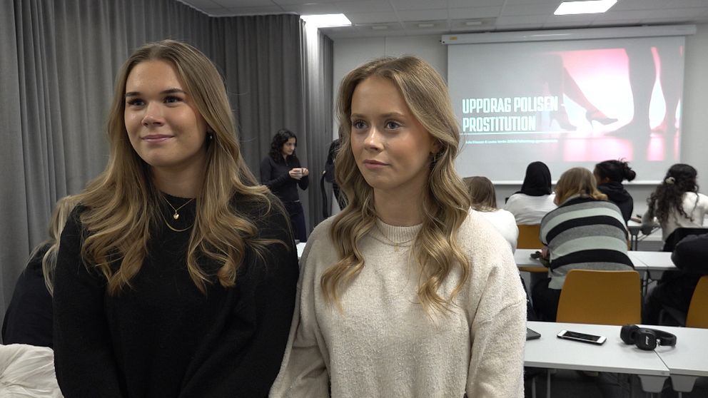 Ella Lööf och Elsa Svensson står i en klassrumsmiljö med deltagare och en presentation på skärmen.