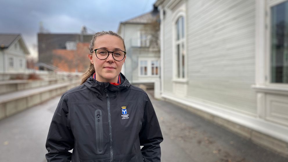 Linnea Davinder, måltidsutvecklare på Östersunds kommun står i en svart jacka, glasögon, på en skolgård i Östersund och intervjuas av SVT.
