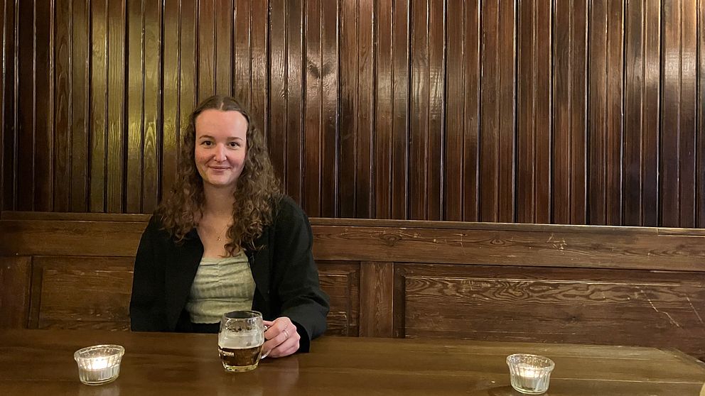 Kvinnliga ölkännaren Amanda Knöös sitter i en bar och dricker en ljus lager.