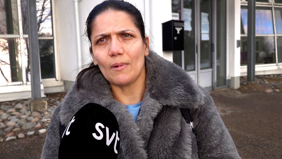 Soraya. klädd i en grå pälsjacka står framför komvux södertälje och pratar in i en mikrofon med SVT-logotyp.