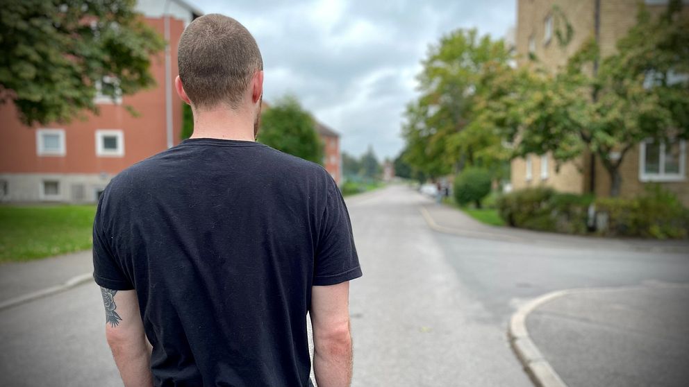 Sebastian står med ryggen mot kameran på en gata i Linköping efter explosionen.