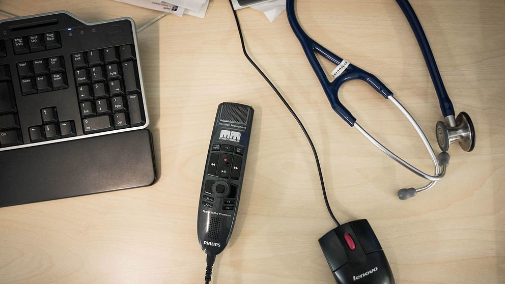 Tangentbord, diktafon och ett stetoskop på ett skrivbord.
