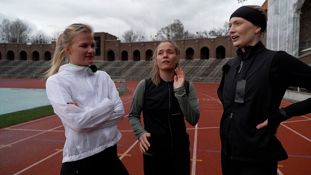 Tre tjejer i löparoutvits på löparbanan på Stockholms Stadion.