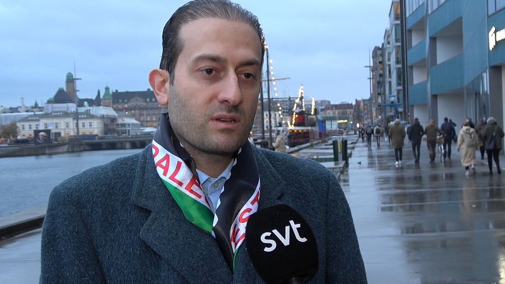 Mouayad Toron utanför Orkanen i Malmö, i grå kappa och en palestinsk flagga runt halsen.