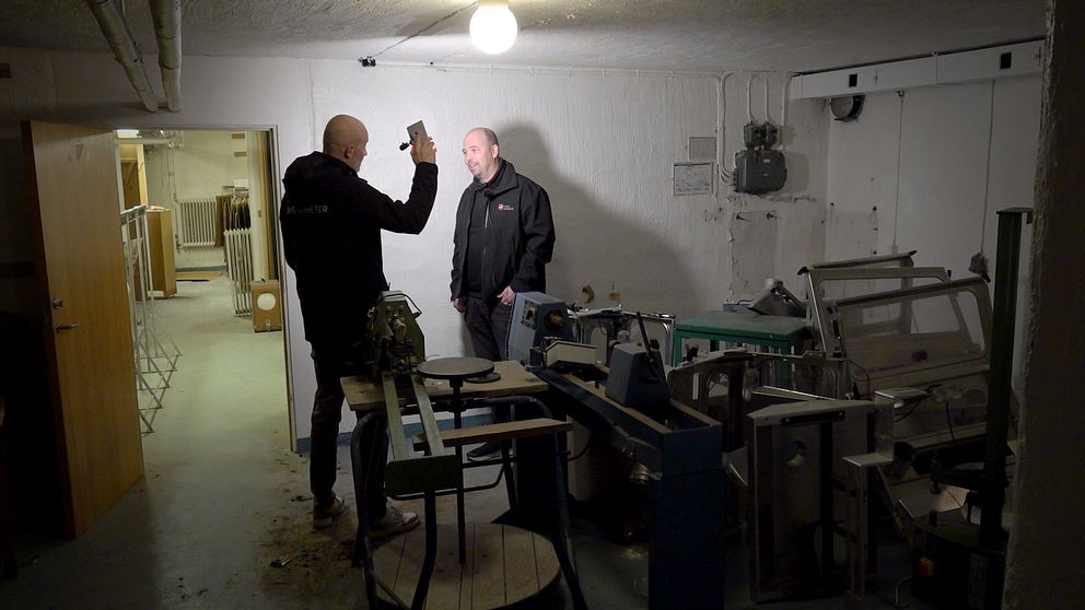 Två män står i ett skyddsrum.