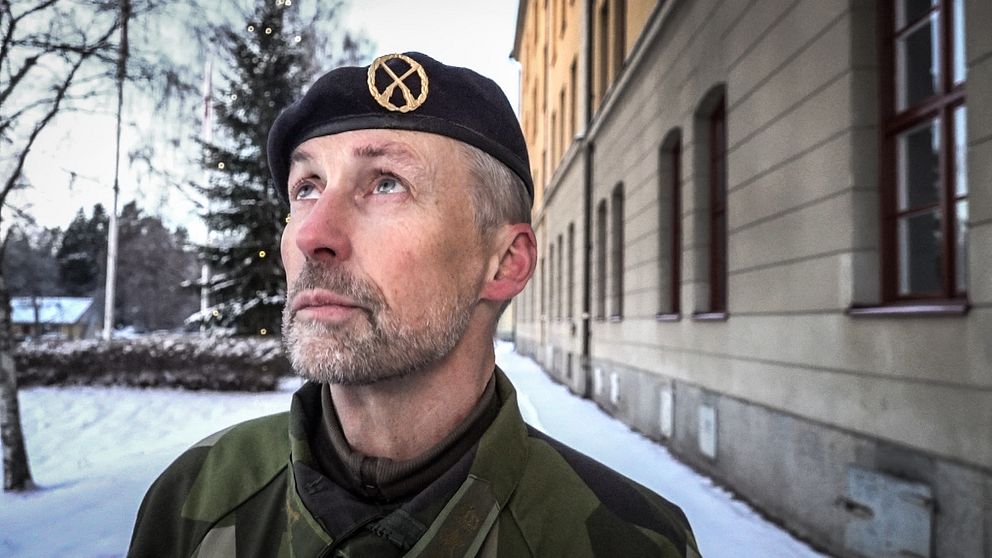 En manlig militär med basker blickar ut över horisonten.