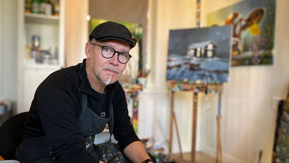 En man, Mathias Kärnlund, konstnär, sitter i sin studio utanför Östersund.