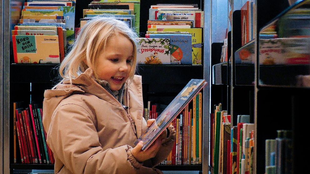 Barn ler och håller i en bok på ett bibliotek i Örebro.