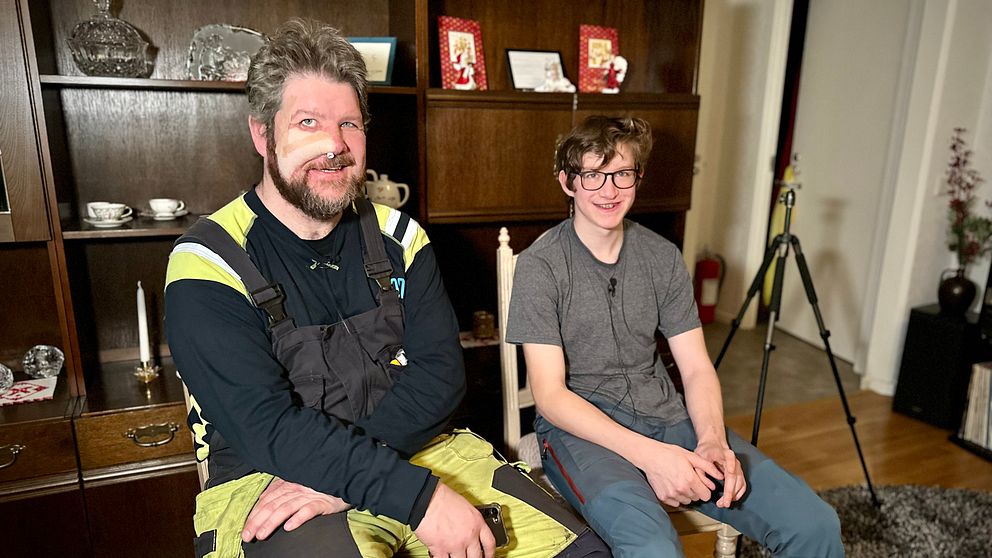 Jägaren Pär Sundström och sonen Evert Sundström sitter på stolar i ett vardagsrum nästan månader efter björnattacken.