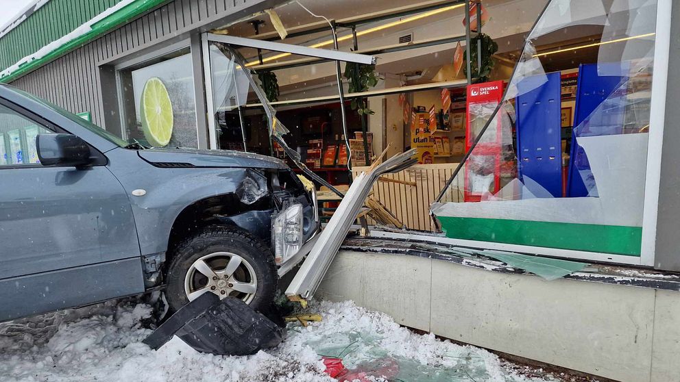 en bil som kraschat in i en förnsterruta i en affär.