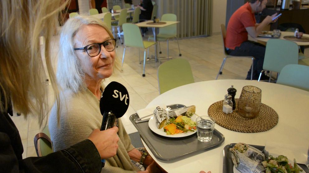 En kvinna sitter på stadhusets restaurang i Södertälje och äter en beredskapsrulle