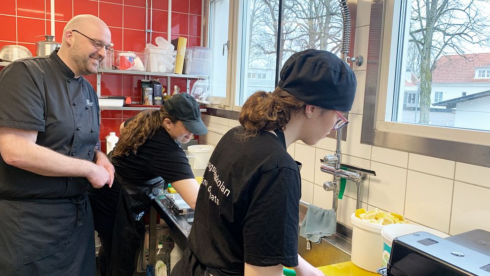 Två elever jobbar i köket med ansvarig kock