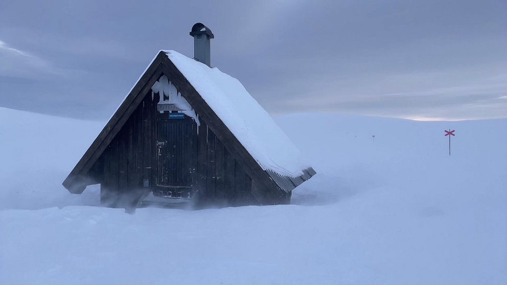 en liten raststuga på fjället, mycket snö och blåst