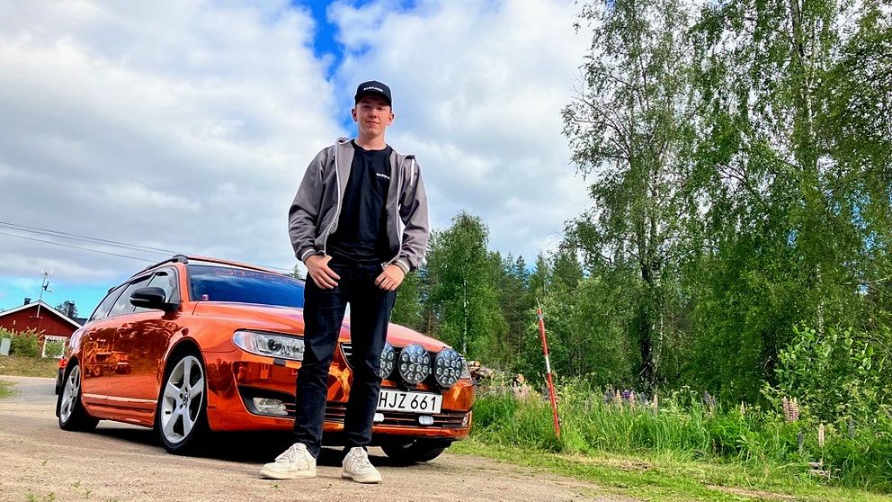En kille i keps framför en mettalicorange epa