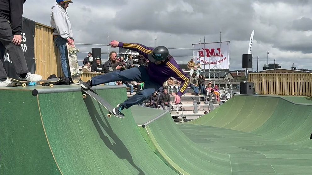 Skateboardåkare gör trick i en ramp inför publiktävling utomhus.