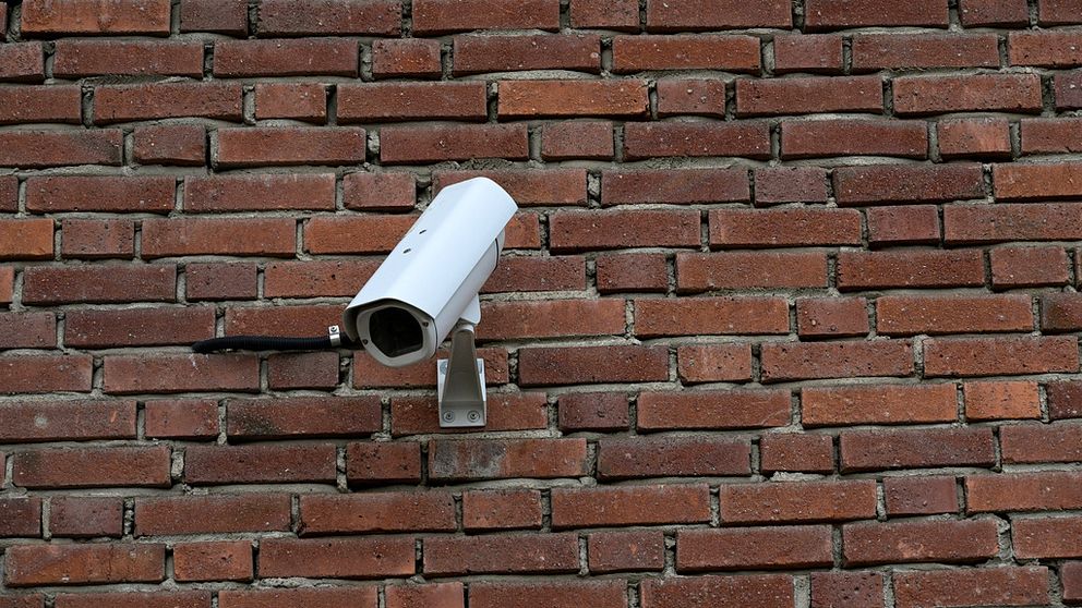 Övervakningskamera på tegelvägg.,