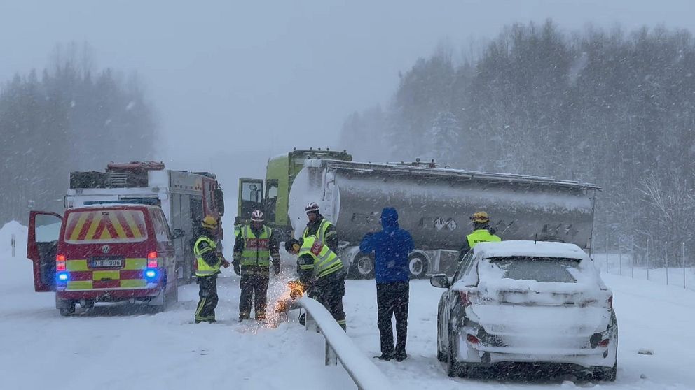 Räddningstjänst sågar mitträcke framför en krashad lastbil
