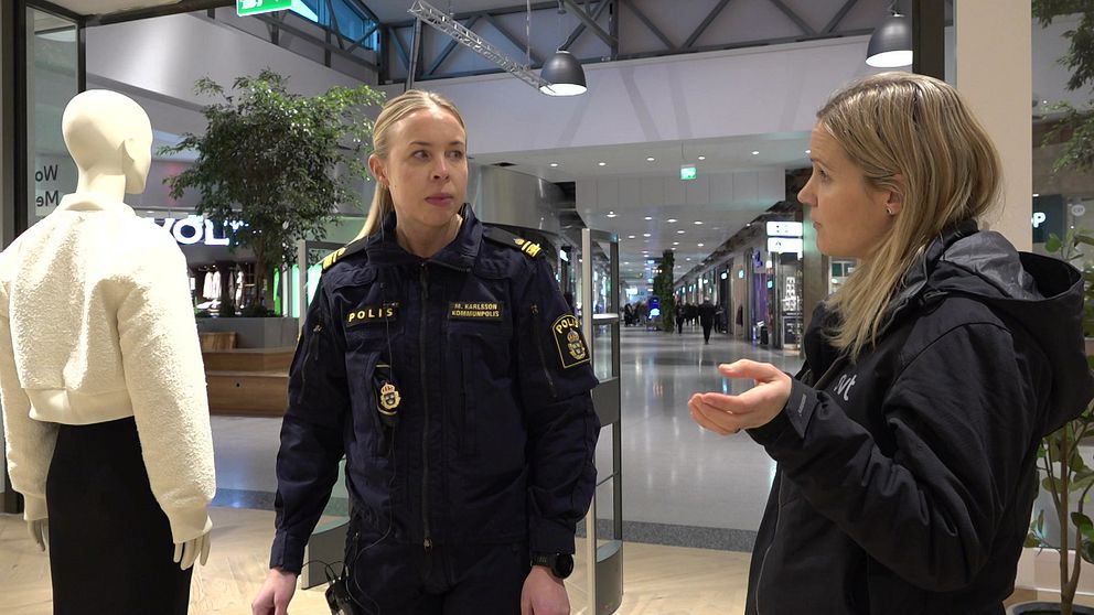 En reporter intervjuar en polis i en klädbutik