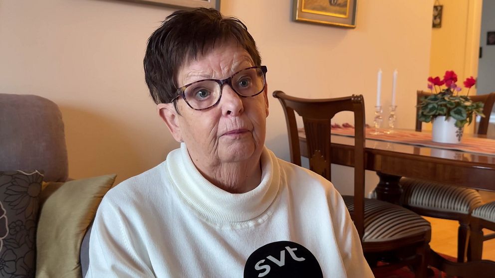 76-åriga Margit Brandin i sitt hem, sitter i soffan, matsalsbord i bakgrunden.