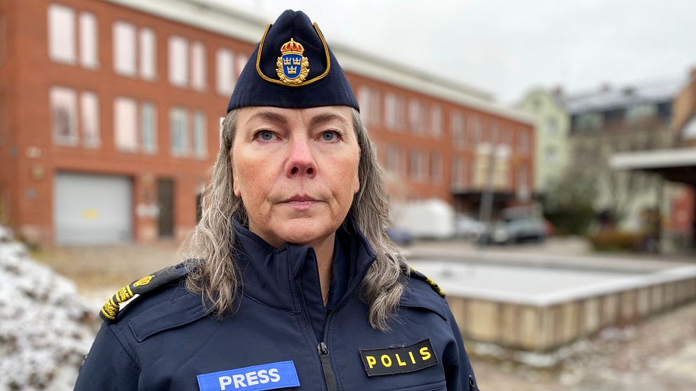 kvinna i polisuniform med presslogga