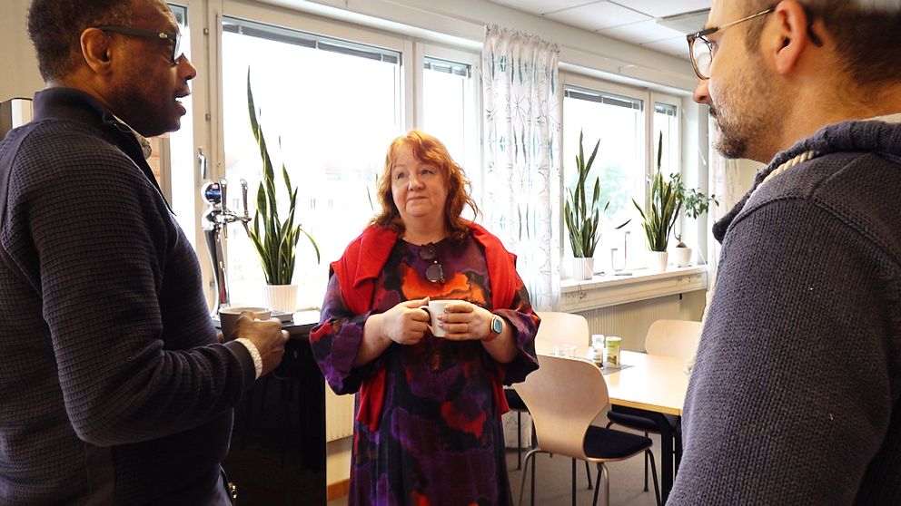 Forskaren Lina Lid Falkman vid Karlstads universitet står i fikarummet med en kaffekopp i handen och pratar med sina kollegor.